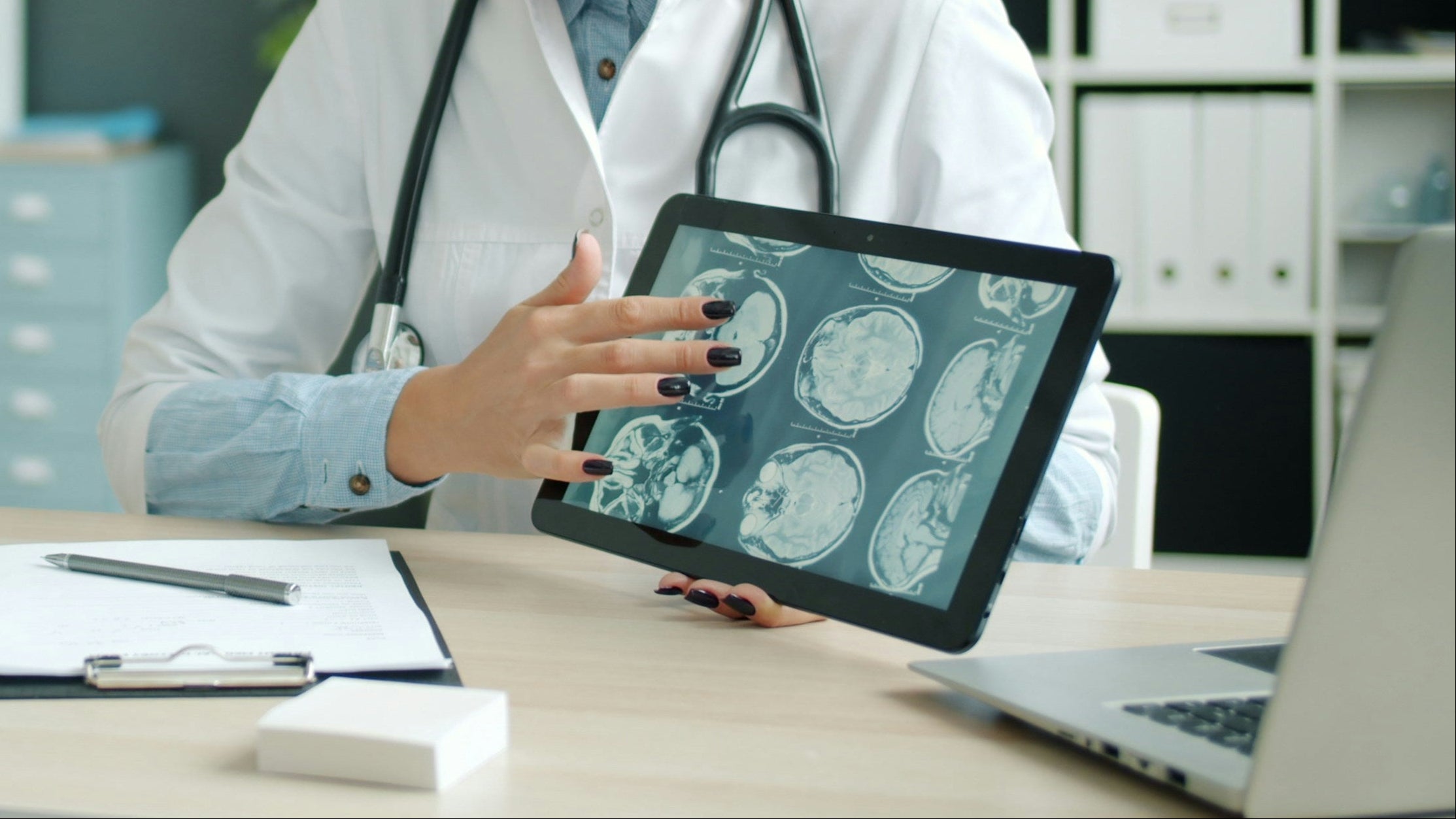 Doctor using a tablet with a patient in an office setting