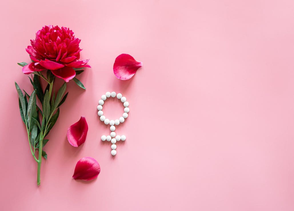 Gender Venus symbol made of pills, and peony flower on a pink background. Cancer Types We Treat